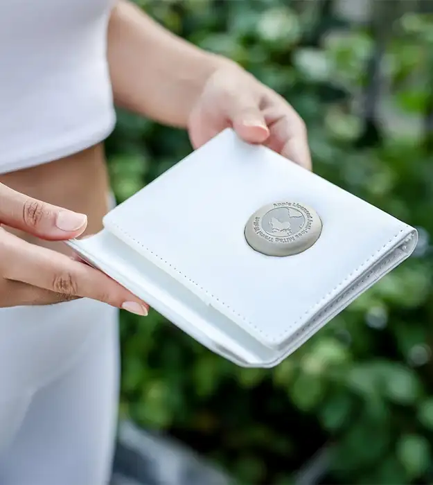 Kožni putni novčanik za pasoš sa ugrađenim Bluetooth trackerom, bele boje, položen na prtljag